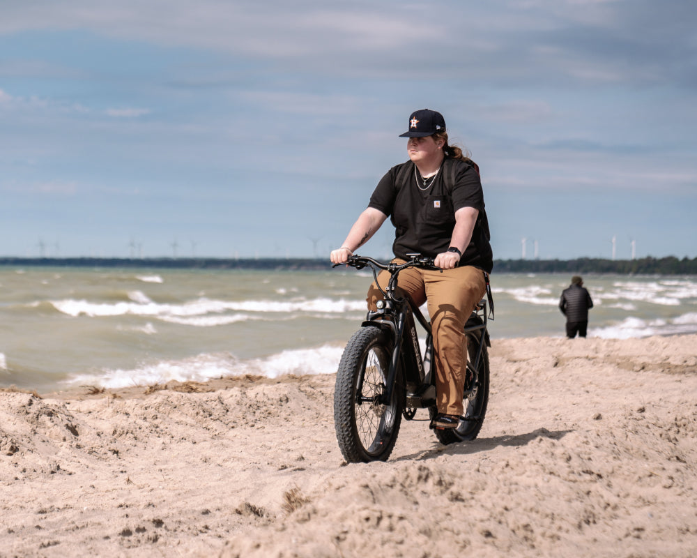 Real customer riding the Terra X1 by SPACEVELO on a sandy beach, sharing a testimonial about the bike's exceptional battery life and comfort, transforming daily commutes into exhilarating experiences.