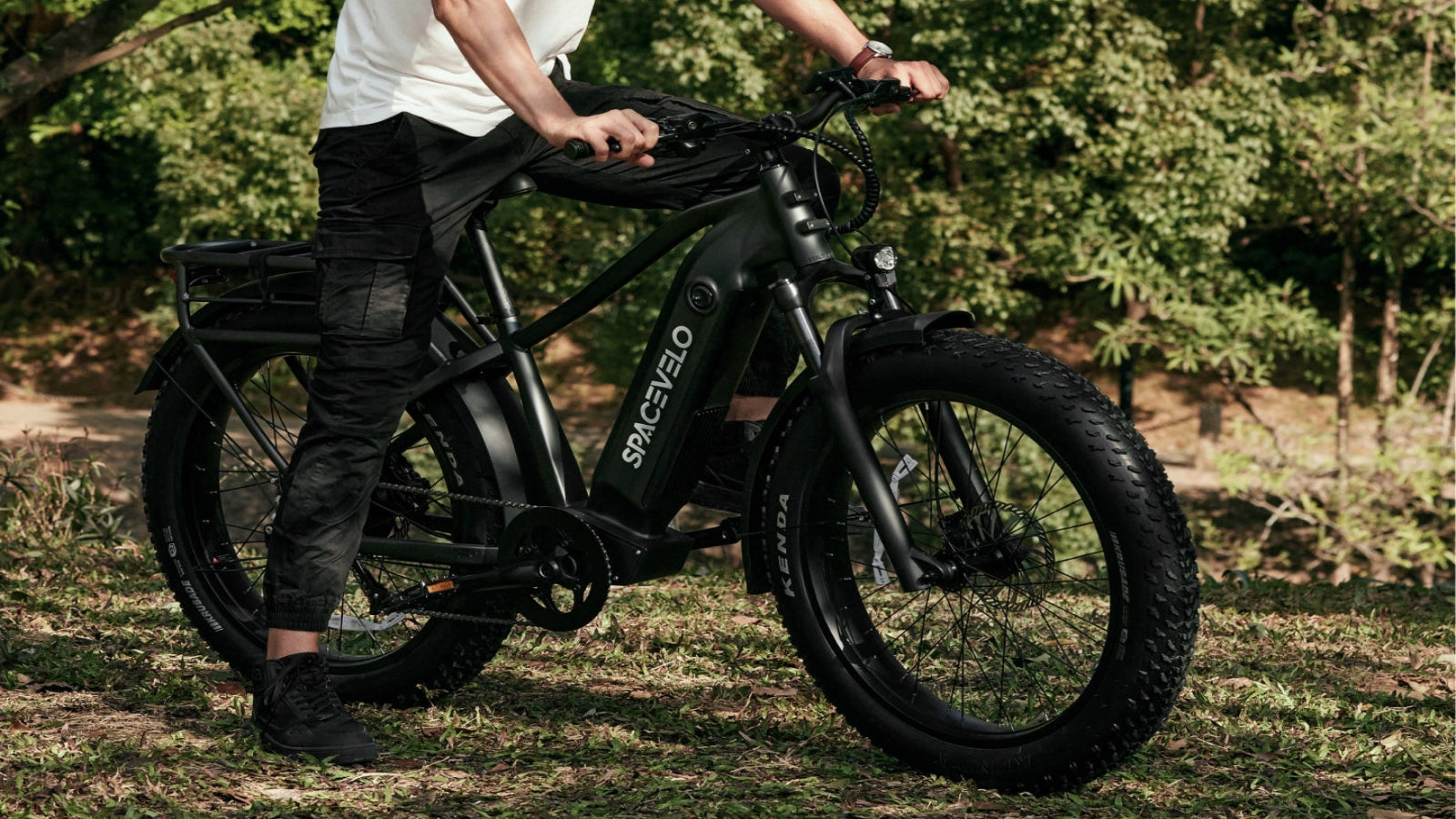 Model riding a SPACEVELO electric bike on an outdoor trail, showcasing the bike's sleek design and rider's ease of use.